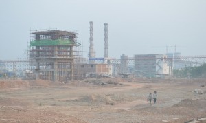 two workers are walking away from the incomplete buildings of Mawlamyine Cement Limited (Photo: MNA)