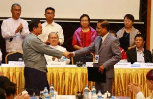 NMSP leader Nai Hongsar (R) shakes hands with government leader U Aung Min (L) after signing a nationwide ceasefire draft agreement, in March 2015 (Photo: RFA).